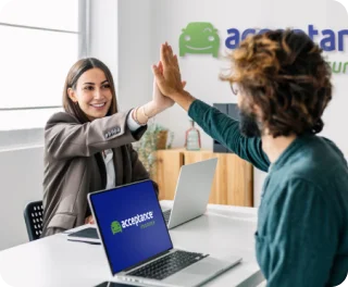 Two people giving a high-five at an Acceptance Insurance office