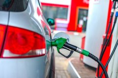 A car refuels at a gas station pump, representing everyday strategies drivers use to find cheap gas and save money at the pump.