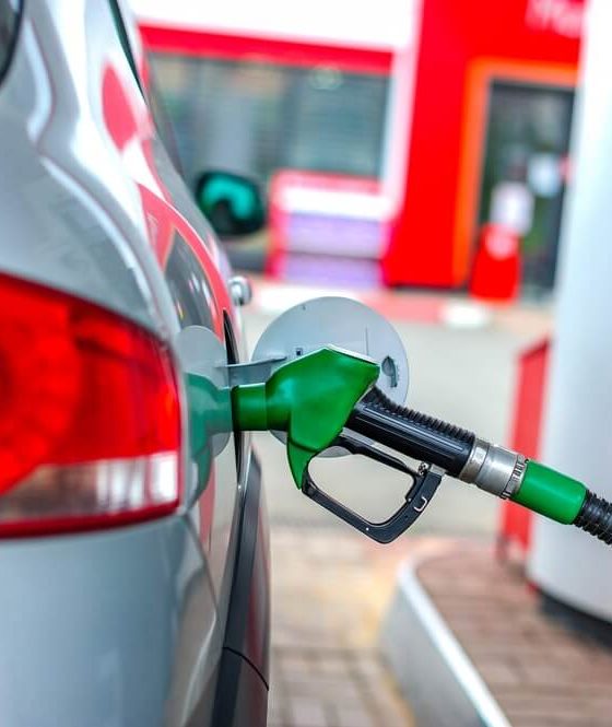 A car refuels at a gas station pump, representing everyday strategies drivers use to find cheap gas and save money at the pump.
