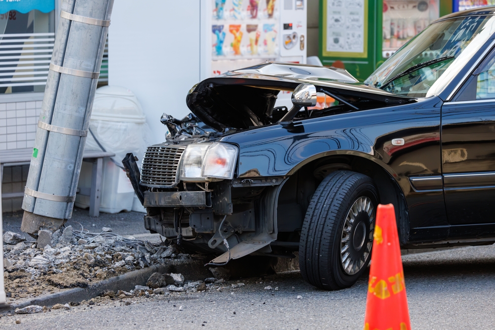 Car with severe front-end damage after hitting a pole, showing how liability insurance can help when an accident causes damage to someone else’s property.