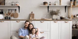 Happy family sitting in their kitchen, representing security and peace of mind with reliable homeowners insurance cover
