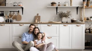 Happy family sitting in their kitchen, representing security and peace of mind with reliable homeowners insurance cover