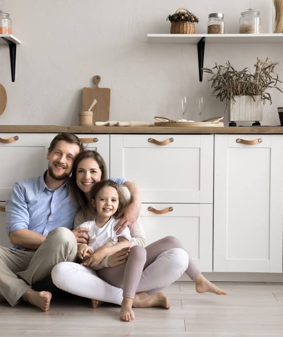 Happy family sitting in their kitchen, representing security and peace of mind with reliable homeowners insurance cover