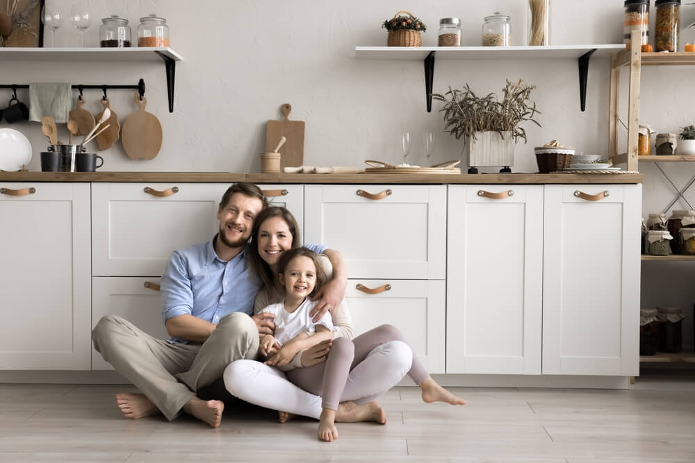 Happy family sitting in their kitchen, representing security and peace of mind with reliable homeowners insurance cover