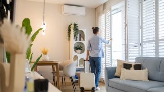 Renter with suitcase in a bright apartment learning how to get the best deal on an apartment.