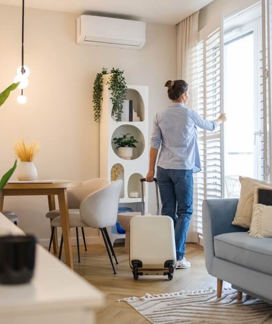 Renter with suitcase in a bright apartment learning how to get the best deal on an apartment.