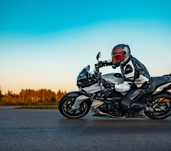 Motorcyclist riding a sport motorcycle on an open road at sunset, representing motorcycle insurance and rider safety.