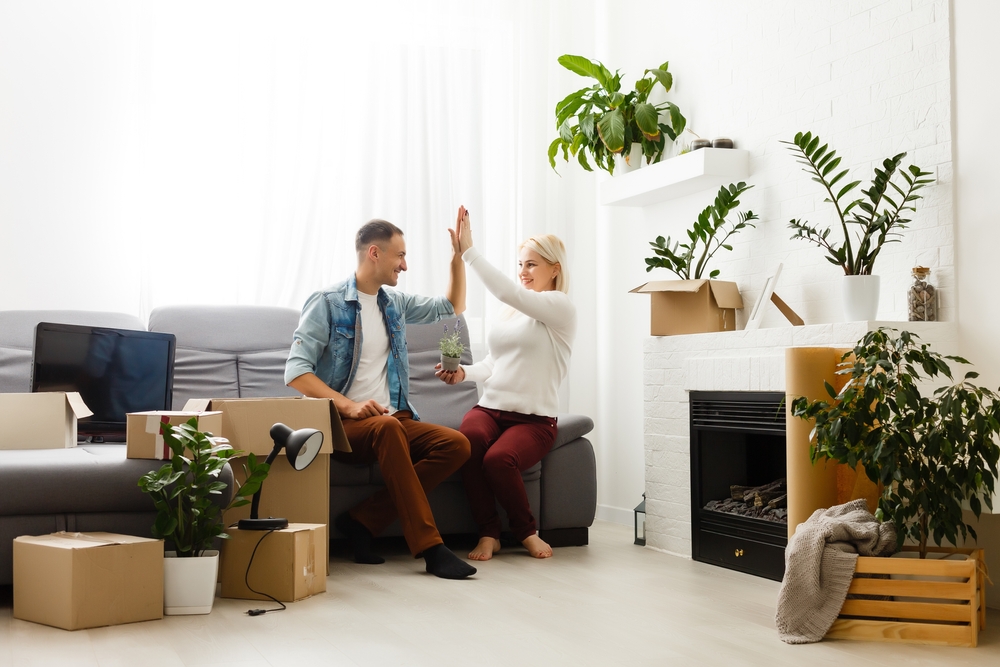 Young couple decorating their rented home with plants