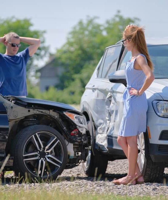 Two drivers stand beside damaged vehicles after a crash, showing how collision insurance can help cover repairs after an accident.