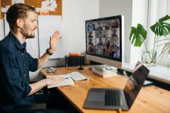 Man working from home on a conference call with remote teammates, home office, home insurance.