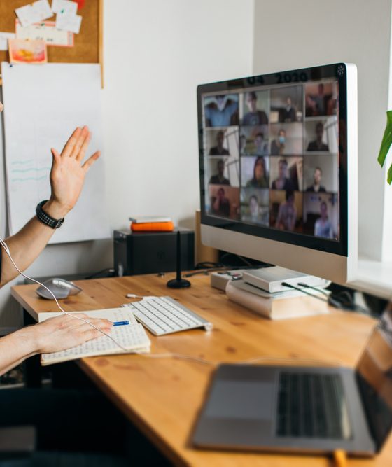 Man working from home on a conference call with remote teammates, home office, home insurance.