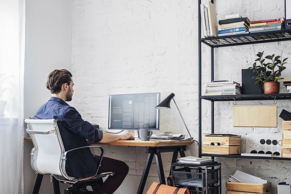 Man sits at his desk, concept of working from home, home office and home insurance.