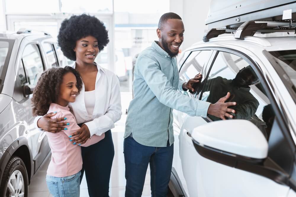 Mom, dad and daughter check out the new cars at a dealership and decide whether to lease or buy their new vehicle.