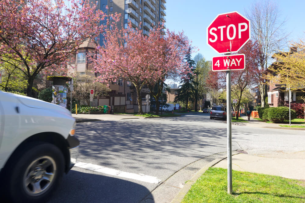 Car pulling up to a 4-way stop sign, rules of the road, how to handle a 4-way stop sign.