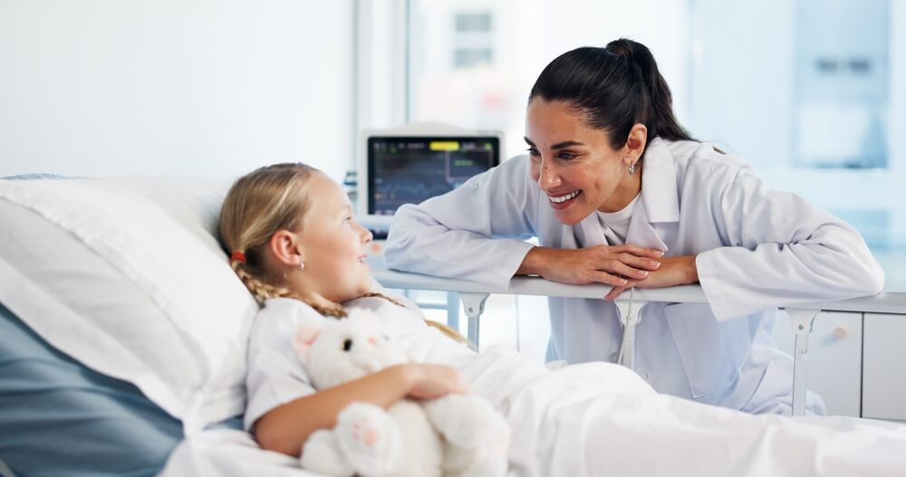 Healthcare, doctor and child in bed for recovery, treatment update and teddy bear for comfort. Girl patient, pediatrician and happy in hospital for successful surgery, medical support and health insurance.