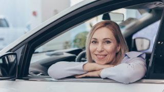 Woman sitting in a new automobile wondering How Often Should You Review Your Car Insurance