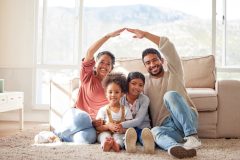 Family, roof and portrait with children in home for protection, love and insurance on floor. Happy, house and mother, father and kids with people hands cover for safety, security and support.
