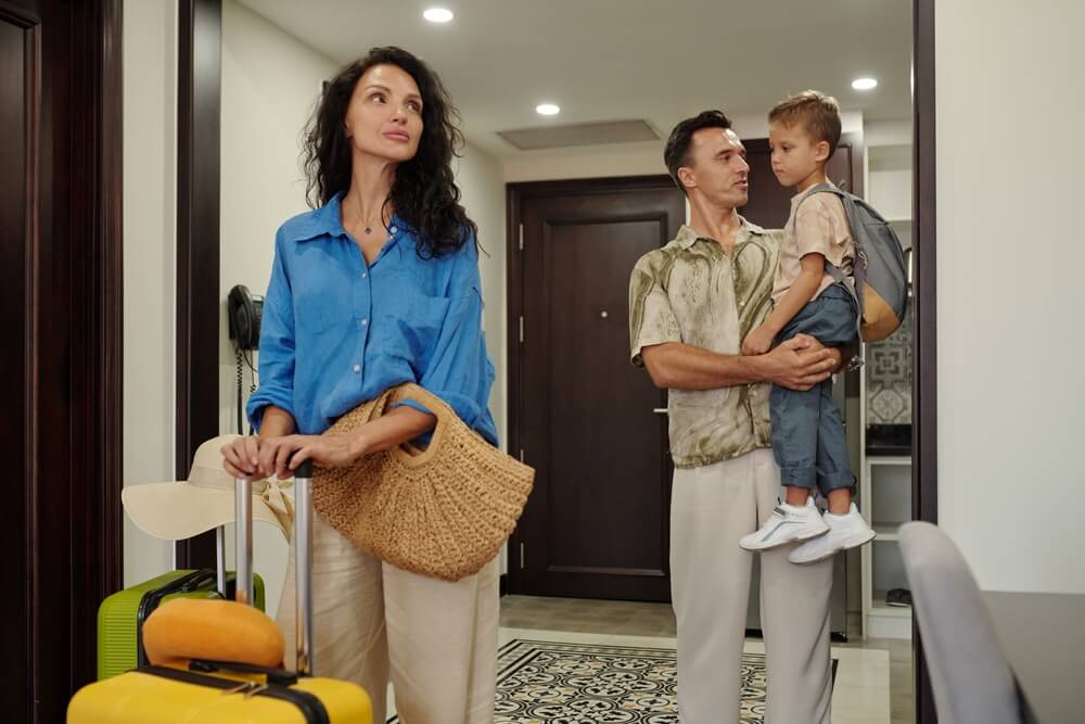 Family arriving at a temporary housing rental with luggage, highlighting situations where homeowners insurance can help cover temporary housing needs