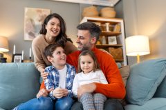Happy family relaxing on the sofa at home, representing the protection homeowners insurance provides