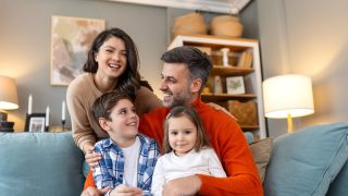 Happy family relaxing on the sofa at home, representing the protection homeowners insurance provides