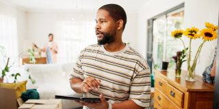 Thinking, tablet and moving with black man in new home for relocation, furniture inventory and real estate. Boxes checklist, property investment and reflection with couple in living room for planning.