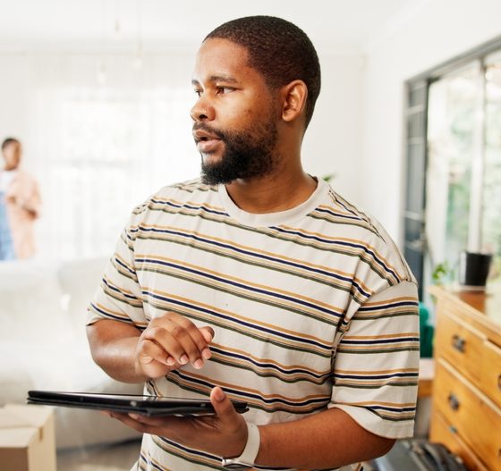 Thinking, tablet and moving with black man in new home for relocation, furniture inventory and real estate. Boxes checklist, property investment and reflection with couple in living room for planning.