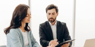A woman reviewing insurance paperwork with an advisor, reflecting concerns about choosing coverage when the deductible is too high