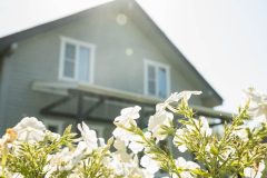 House exterior with blooming flowers in spring, symbolizing the right time for a spring home insurance review and policy check.