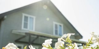 House exterior with blooming flowers in spring, symbolizing the right time for a spring home insurance review and policy check.