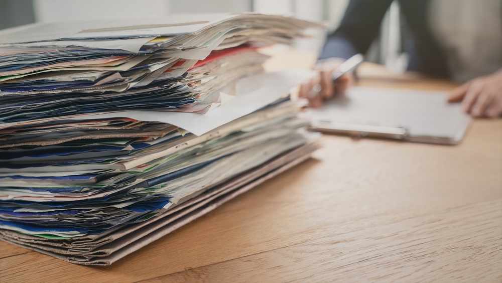 Stack of insurance documents and paperwork on a desk.