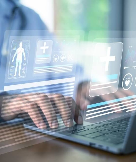 Healthcare professional using a laptop with digital medical records and insurance icons, illustrating health coverage options during Covered California open enrollment.