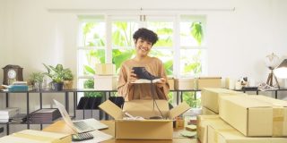 Small business owner packing customer orders while considering home-based business insurance coverage.