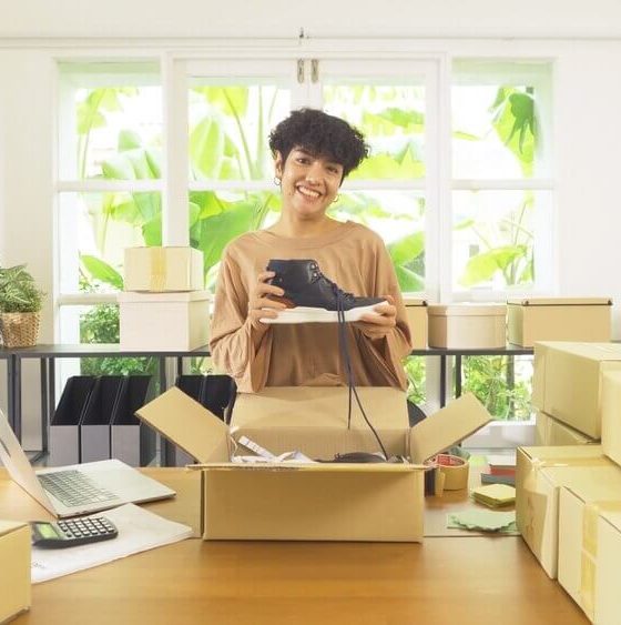 Small business owner packing customer orders while considering home-based business insurance coverage.