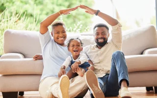 Happy black family, portrait and roof with protection for mortgage, investment or moving in new home.