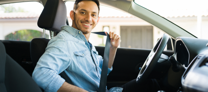 Portrait of an attractive Latin man smiling before starting to work as a taxi driver of a car sharing service on a mobile app