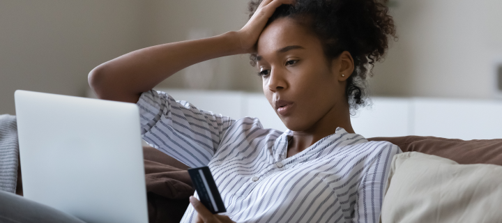 Unhappy millennial African American woman distressed with problems paying online on laptop with credit debit card. Upset young ethnic female confused have troubles shopping on web on computer.