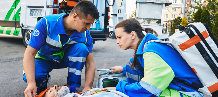 Paramedics immobilized senior patient with neck brace and spinal board to prevent damage in case of spinal injury. First aid from ambulance technicians.