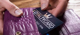 Close-up Of A Businessperson's Hand Removing Loyalty Card From Purse
