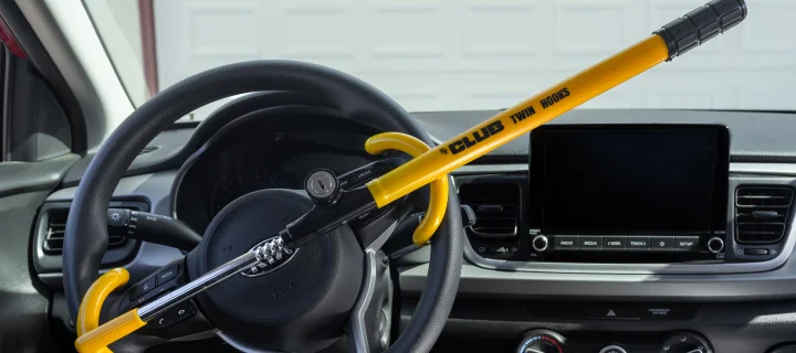 Victorville, CA, USA – August 11, 2022: The Club Twin Hook steering wheel security lock in yellow attached to a Kia car.