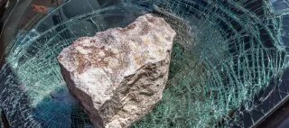broken car windshield with a huge stone.