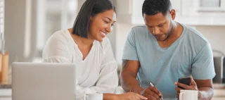 Shot of a couple going over paperwork together at home.