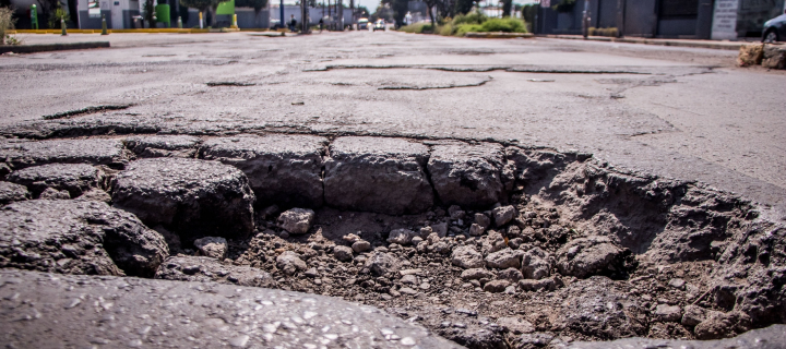 Street pothole on deteriorated asphalt pavement.