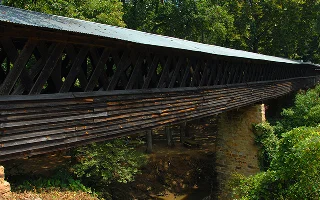 Clarkson Covered Bridge, in Cullman, Alabama, is wooden and extremely long and crosses Crooked Creek. Tin roof covers bridge, cheap car insurance in Alabama.