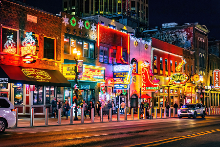 Nashville, TN, USA - 12-24-2023: Famous Neon signs of blues clubs on Beale street illuminated at night in downtown Nashville city attraction – Nashville, cheap car insurance in Tennessee