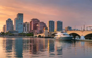 Cityscape image of West Palm Beach, Florida with reflection of the city skyline in the water at beautiful sunset – West Palm Beach, cheap car insurance in Florida