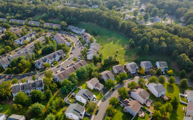 Aerial view of a residential neighborhood in Parma, Ohio, surrounded by trees and green space.